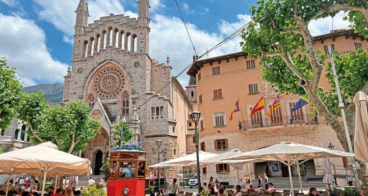 Historic square with a cathedral and outdoor cafes.
