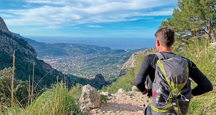 Hiker looking at a panoramic view of the coastline and valley.