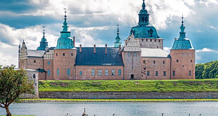 Historisches Schloss am Wasser mit mehreren Türmchen.