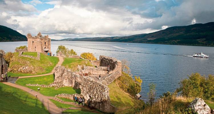 Historische Burgruinen an einem See mit einem Boot.