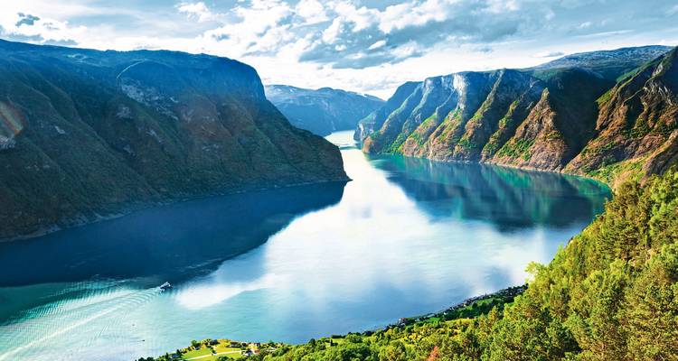Dramatic fjord view with steep mountain cliffs.
