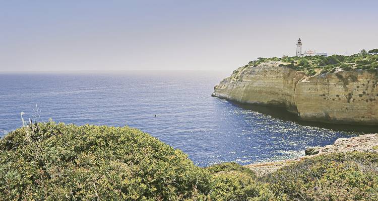 Eine Küstenklippe mit einem Leuchtturm mit Blick auf den ruhigen blauen Ozean.