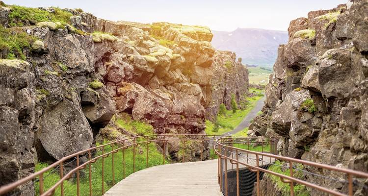 Pfad zwischen Felsformationen mit durchscheinendem Sonnenlicht.