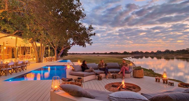 Relaxing outdoor seating by the riverside with sunset views.