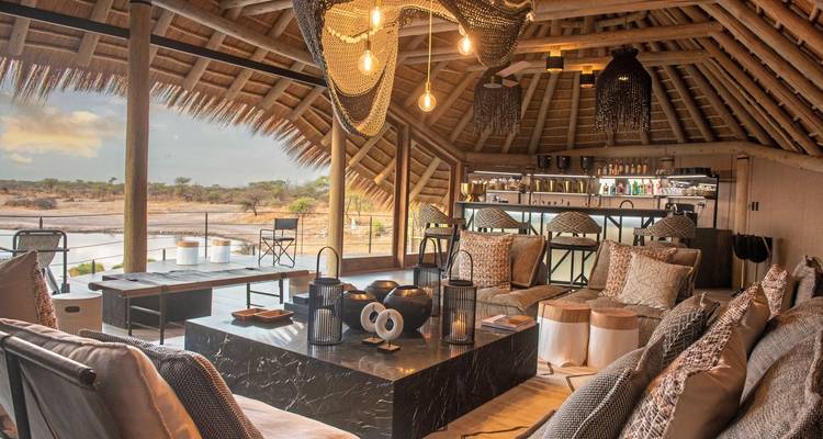 Luxurious open-air lodge interior with elegant furnishings.