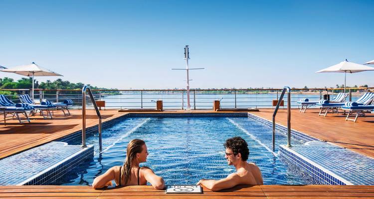 Paar entspannt in einem Pool auf einem Kreuzfahrtschiff.