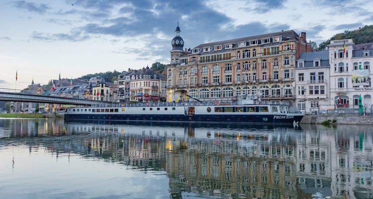 Cruiseschip aangemeerd bij historische stadsgebouwen.