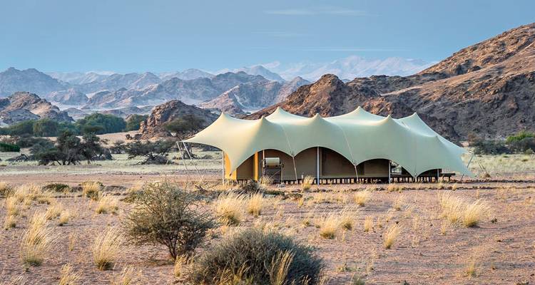 Glamping-Zelt in Wüstenlandschaft.
