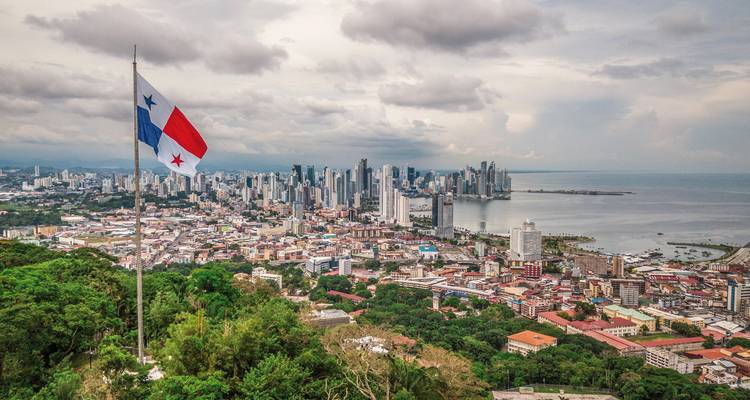 Aerial view of Panama City skyline with a flag in the foreground.