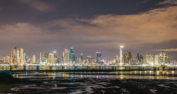 Panama City skyline at night with illuminated buildings.