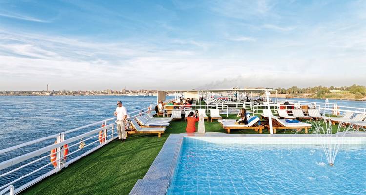 Menschen entspannen am Pool auf dem Deck eines Kreuzfahrtschiffs.
