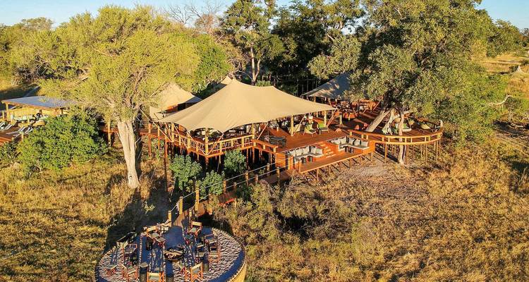 Vue surélevée d'un chalet en bois entouré d'arbres.