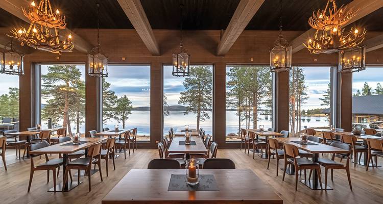 Restaurant mit großen Fenstern mit Blick auf einen See.