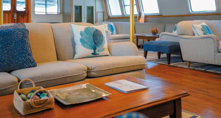 Loungeruimte met banken en een tafel op een schip.