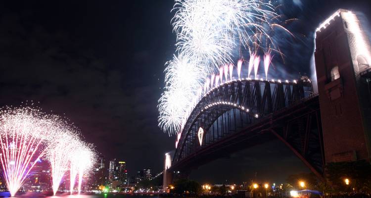 Fireworks over Sydney Harbour Bridge at night.