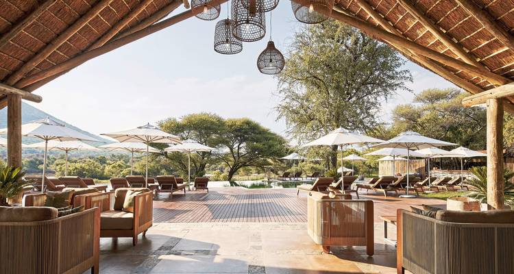 Resort loungeruimte met buitenterras en parasols.