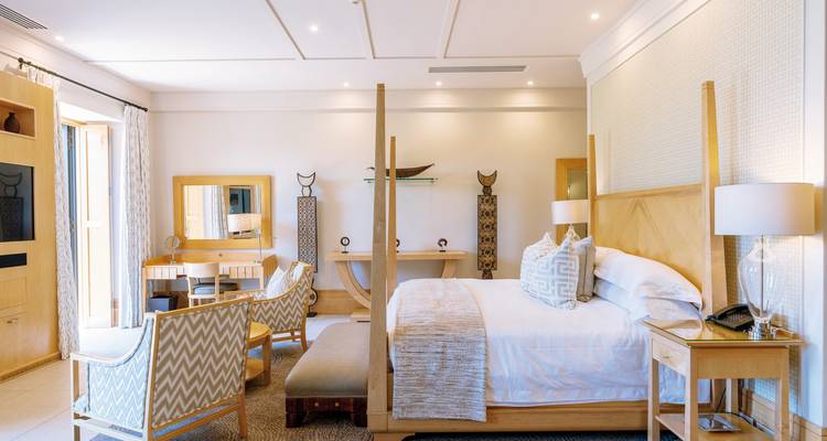 Elegante hotelkamer met lichte kleurenpalette en comfortabele zitplaatsen.