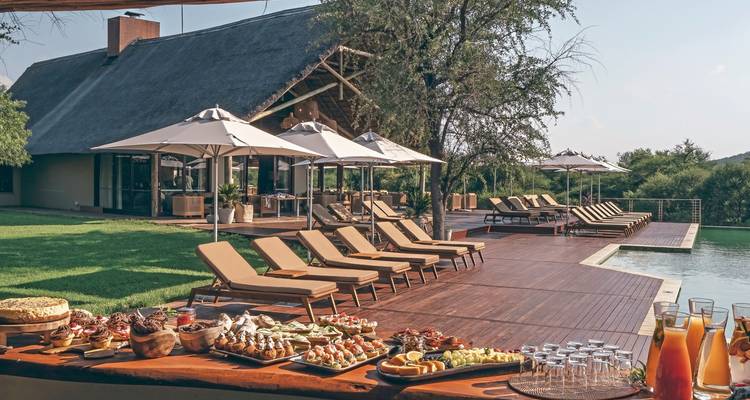 Buiten resortgebied met ligstoelen en een eethoek.