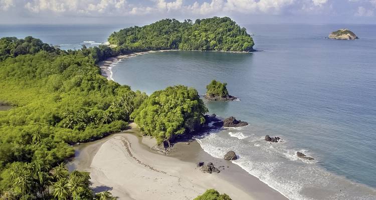 Vista panorámica de una península verde y exuberante con una playa de arena.