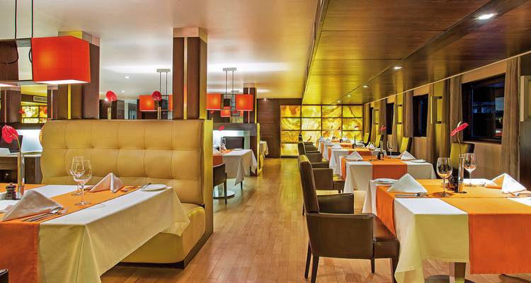 Área de comedor bien organizada con decoraciones naranjas.