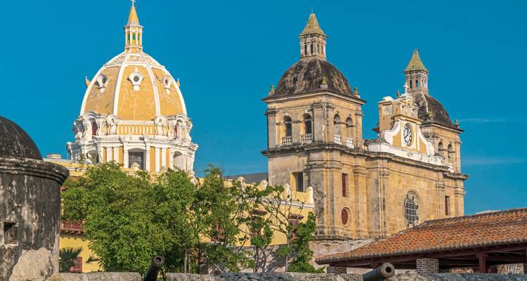 Colorful historic cathedral with domes in a cityscape.