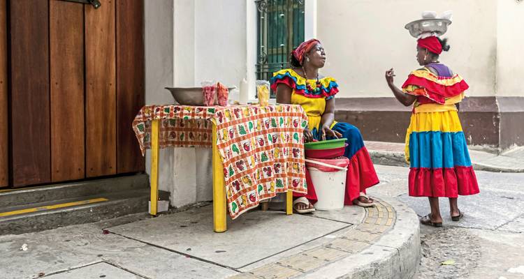 Street scene with two women in colorful traditional attire.