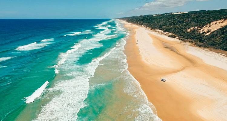 Vista aérea de una larga playa de arena con olas.