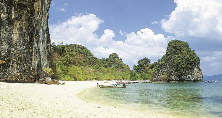 Plage tropicale isolée avec rochers de calcaire.