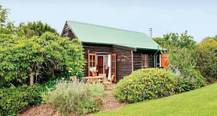 Cozy cottage surrounded by lush greenery.