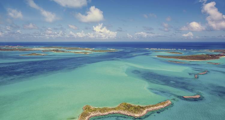 Aerial view of small islands and clear blue water.