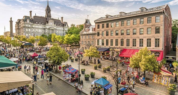 Une place de ville animée avec des bâtiments historiques et une foule.