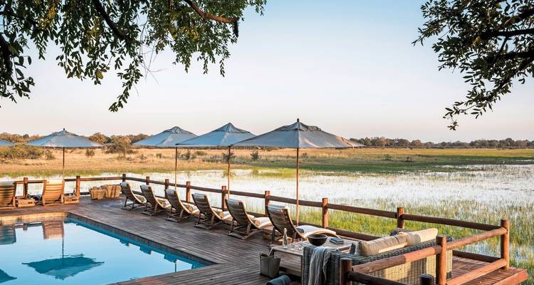 Luxury lodge with pool overlooking a wetland area.
