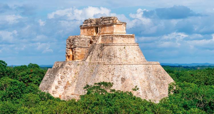 Ancient stone pyramid with green landscape around