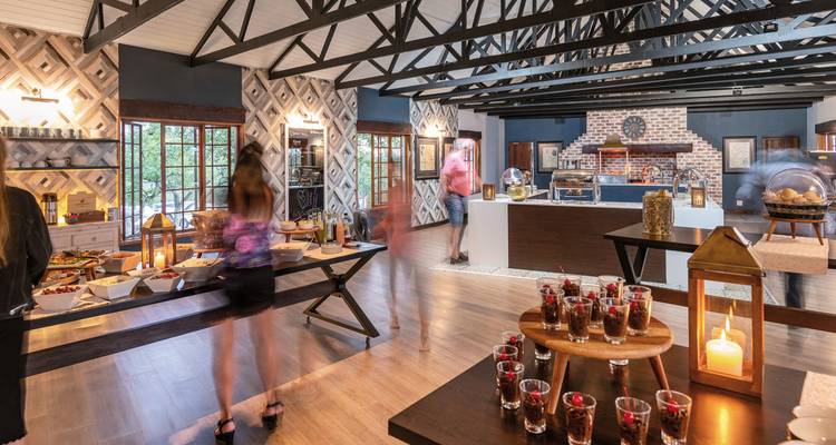 Buffet with people walking around in a stylish dining area.