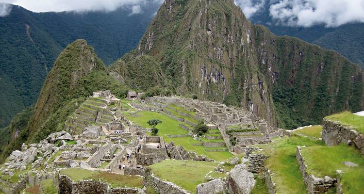 Antike Ruinen von Machu Picchu mit grünen Terrassen und bergiger Kulisse.