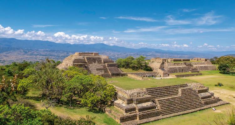 Ruines avec un arrière-plan montagneux sous un ciel dégagé.