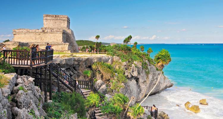 Ruines mayas à flanc de falaise surplombant une mer turquoise.