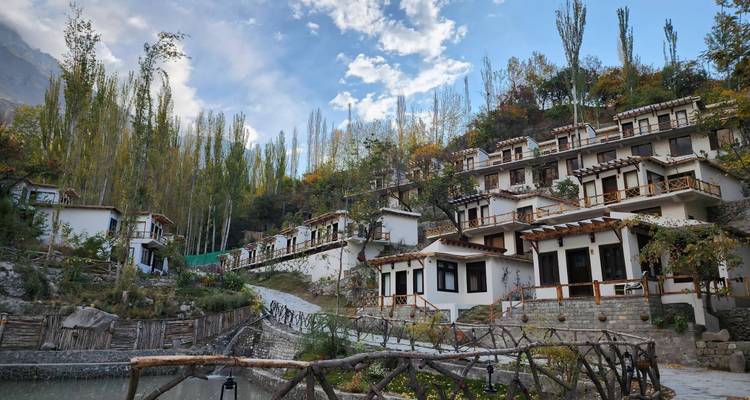 Terraced hillside resort of chalet-style buildings among tall poplar trees.