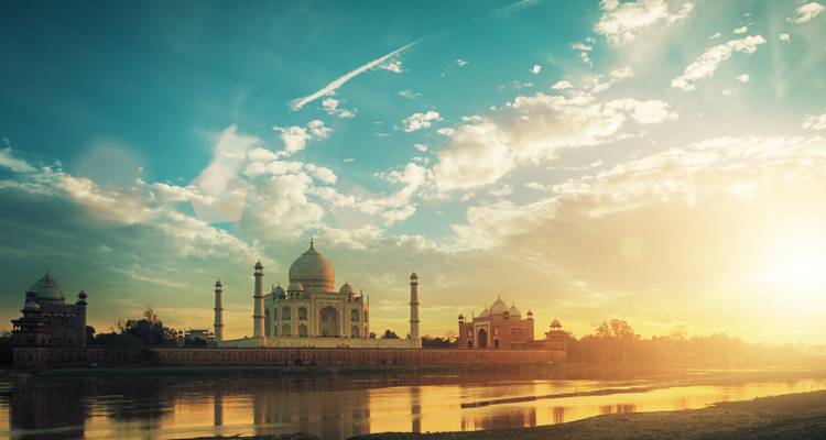 Taj Mahal mit einer Sonnenaufgangs-Spiegelung im Fluss.