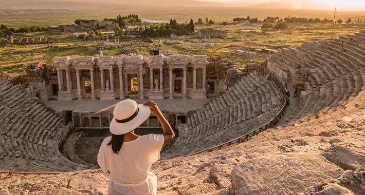 Person admiring an ancient amphitheater with a panoramic view.