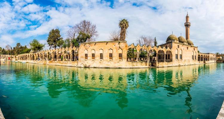 Reflective pool with a mosque in the background.