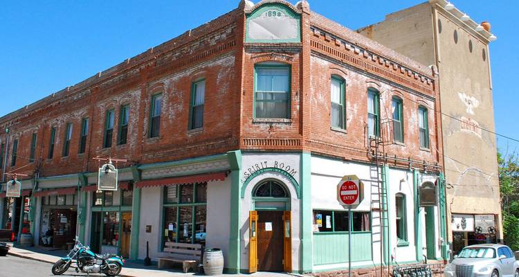 L'immeuble historique en brique à l'angle de la rue, portant l'enseigne Spirit Room, est situé sur une petite rue ensoleillée de la ville de Jerome, en Arizona.