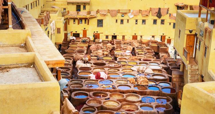 Top view of the colourful vats of the Fes tannery where workers process leather using traditional methods.