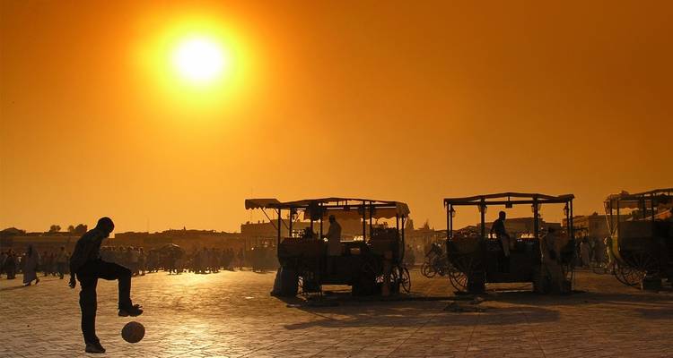 Silhouet van een persoon die met een bal speelt bij zonsondergang.