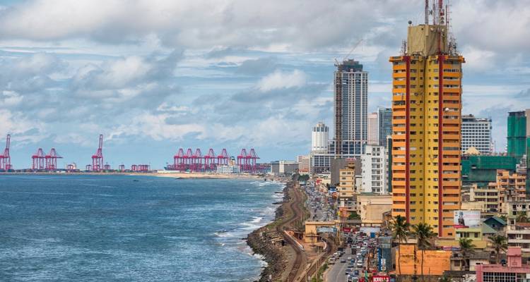 Coastal skyline of Colombo with modern high-rises and port cranes stretching along the ocean