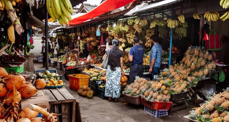 Vibrant fruit and vegetable market bustling with shoppers and overflowing produce