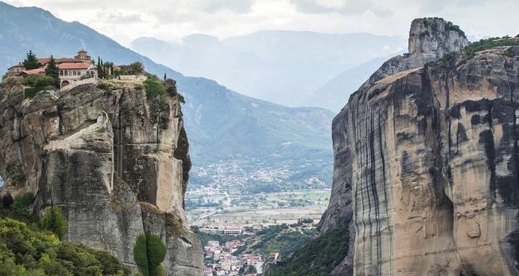 Dramatische rotsformaties met gebouwen op kliffen met uitzicht op een vallei.