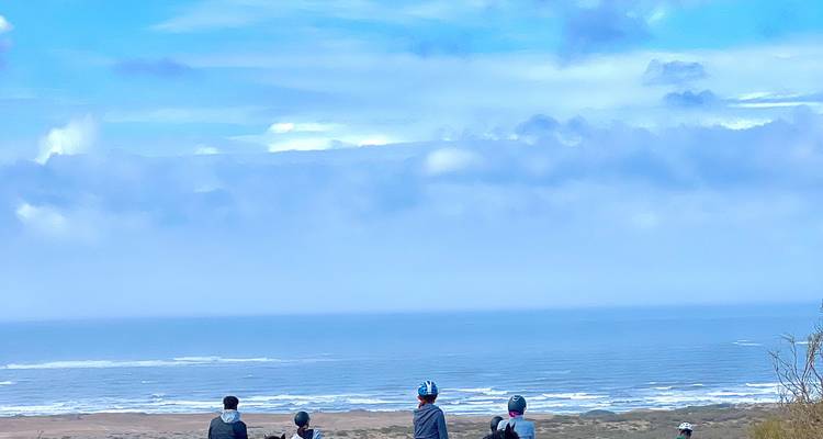 Gruppe von Menschen, die den Blick auf das Meer und den blauen Himmel genießt.