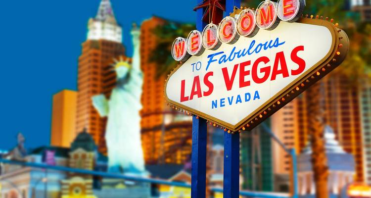 Panneau néon emblématique accueillant les visiteurs à Las Vegas avec la ligne d'horizon de la ville floue en arrière-plan