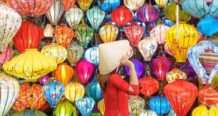 Person admiring colorful lanterns in a vibrant market setting.